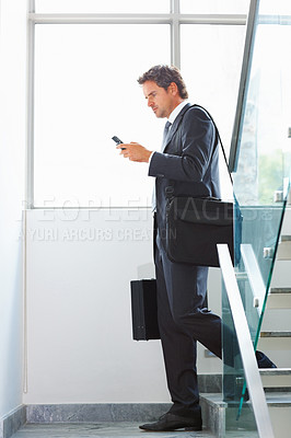 Buy stock photo Full length of handsome middle aged business man using cellphone on stairs