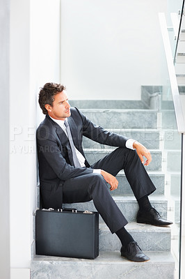 Buy stock photo Full length of thoughtful mature business man sitting on the stairs with a suitcase