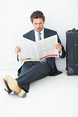 Buy stock photo Business man, newspaper and reading at airport, article and lobby for flight departure or travel. Male person, work trip and information on print or story update, employee and suitcase for journey