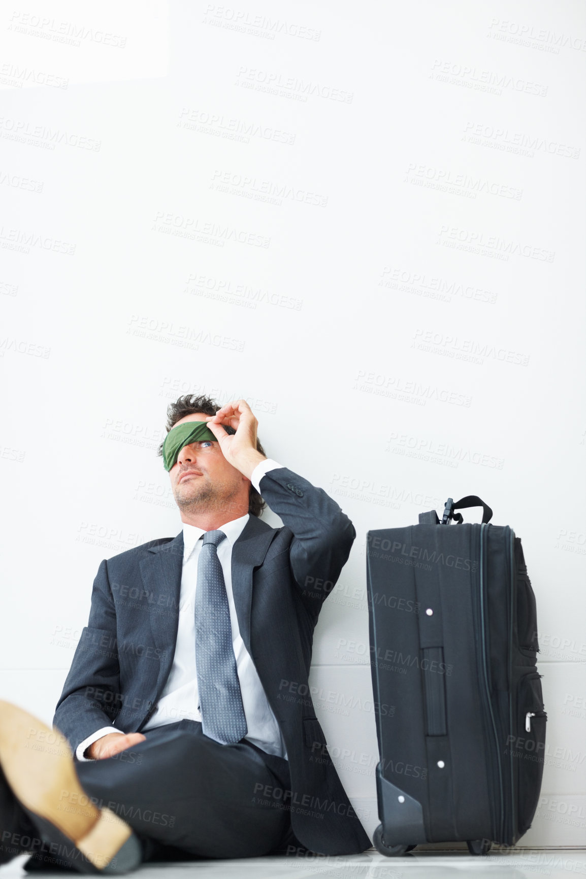 Buy stock photo Waiting, luggage and man with sleep mask in airport for business trip, international flight or departure. Lobby, delay and corporate male person on floor for check in problem, travel or journey