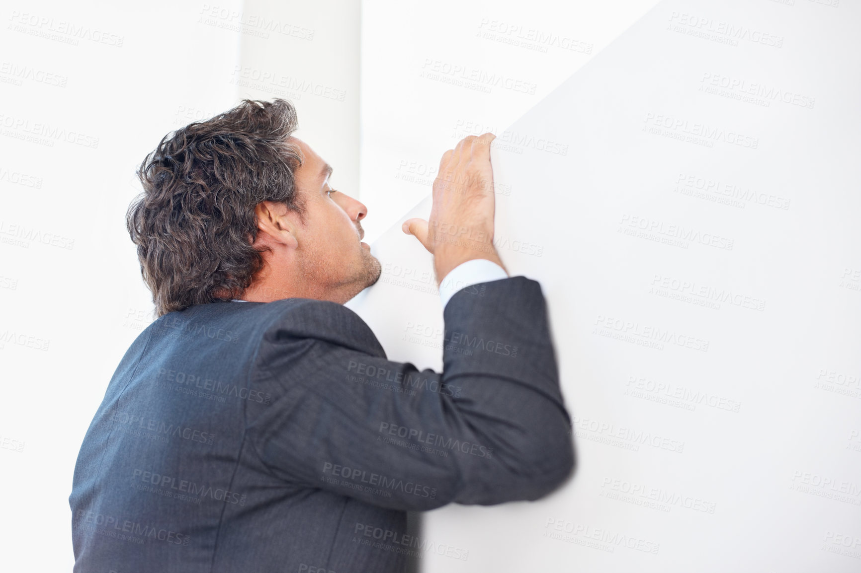 Buy stock photo Smart business man peeking over the wall