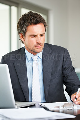 Buy stock photo Middle aged business man working on laptop and taking notes