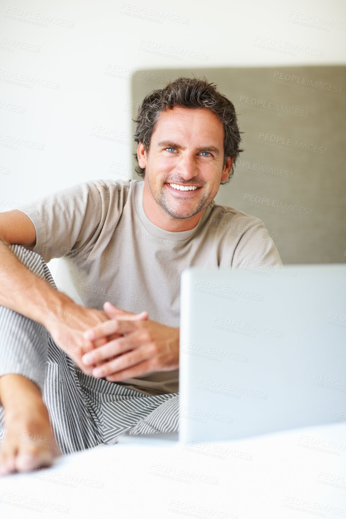 Buy stock photo Portrait, man in bedroom and laptop to work from home, smiling and sitting in bed for freelance career. Technology, entrepreneur and remote worker for online job, company and marketing projects
