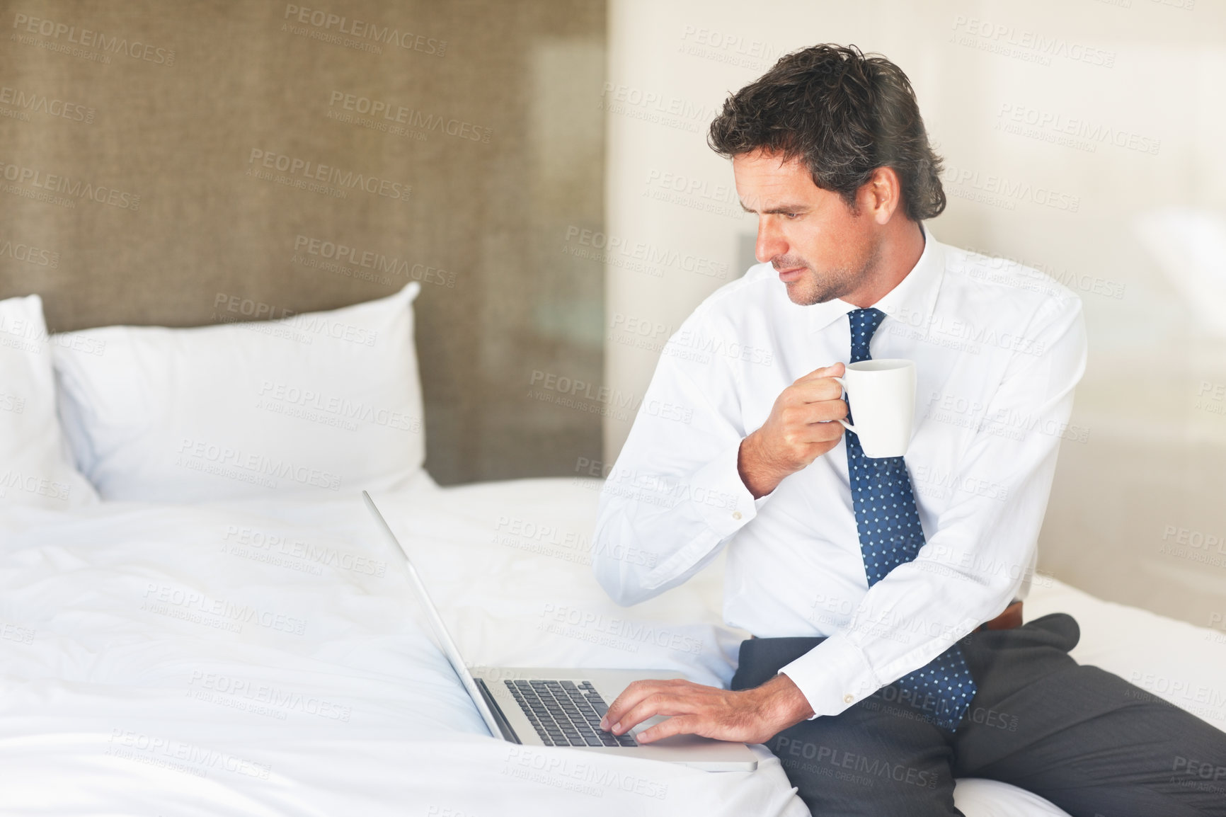 Buy stock photo Laptop, bedroom and coffee with a businessman getting ready for work at his home in the morning while checking an email. Corporate, computer on a bed and a professional employee drinking tea