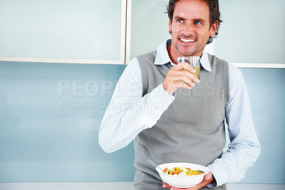 Buy stock photo Smiling mature man looking away with lemon juice and fruit salad
