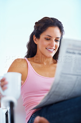 Buy stock photo Happy woman, reading and newspaper with coffee and morning headlines for wellness in living room. Young person, smile and espresso to relax on weekend and current events with warm drink in apartment