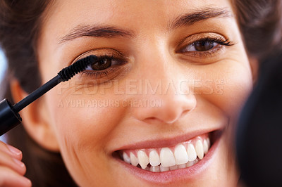 Buy stock photo Face, beauty and lashes with a woman applying mascara to her face for cosmetic treatment and confidence. Closeup headshot of a female looking happy and positive with her skin and eyes closeup