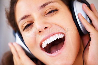 Buy stock photo Excited, headphones and closeup of young woman listening to music, playlist or radio at home. Happy, technology and face of female person from Canada relax and streaming song or album in apartment.