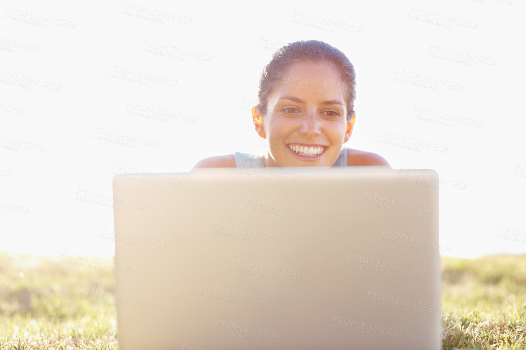 Buy stock photo Laptop, smile and summer with woman on lawn, outdoor in garden for browsing, research or social media. Computer, email and internet with happy person lying on grass in nature or park for wellness