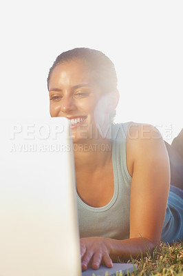 Buy stock photo Happy, laptop and summer with woman on lawn, outdoor in garden for browsing, research or social media. Computer, email and internet with smile of person lying on grass in nature or park for wellness