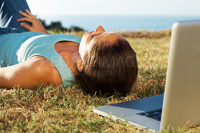 Buy stock photo Woman, laptop and lying on grass for sleep with study break, fatigue and sunshine with relax for online exam. Nap, computer and tired student on outdoor lawn with rest from e learning and education