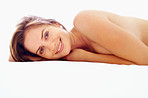 Young topless female lying on the bed with a smile