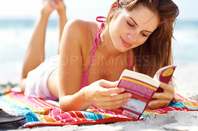 Buy stock photo Beach, woman and bikini with reading book, relax and happy in summer, towel and learning on vacation. Girl, study or novel with thinking, memory and holiday in sunshine, ocean and lying in Naples