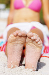 Young woman sitting on sandy beach