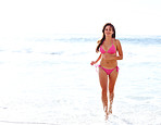 Beautiful young woman in a bikini running on beach