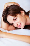 Smiling Caucasian female lying thoughtfully in bed