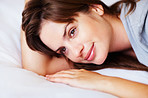 Closeup portrait of a cute thoughtful female lying in bed