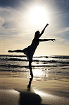 Cute young female dancing on beach at sunset