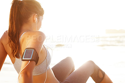 Buy stock photo Runner, woman and relax on beach with music, break and rest after exercise or workout in Sydney. Calm, athlete listening to phone at ocean or sea with peace after running or streaming in training