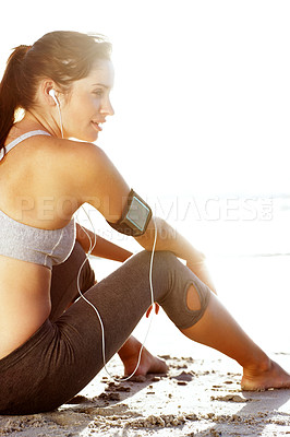 Buy stock photo Woman, tired and fitness on beach with music earphones for wellness, listening and peace of mind. Girl, exercise and break on ocean sand with media player for rest, reflection and workout in morning