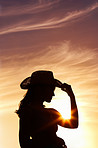 Woman wearing a straw hat against beautiful sunset