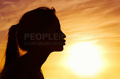 Buy stock photo Profile view of a woman kissing the sun against beautiful sky