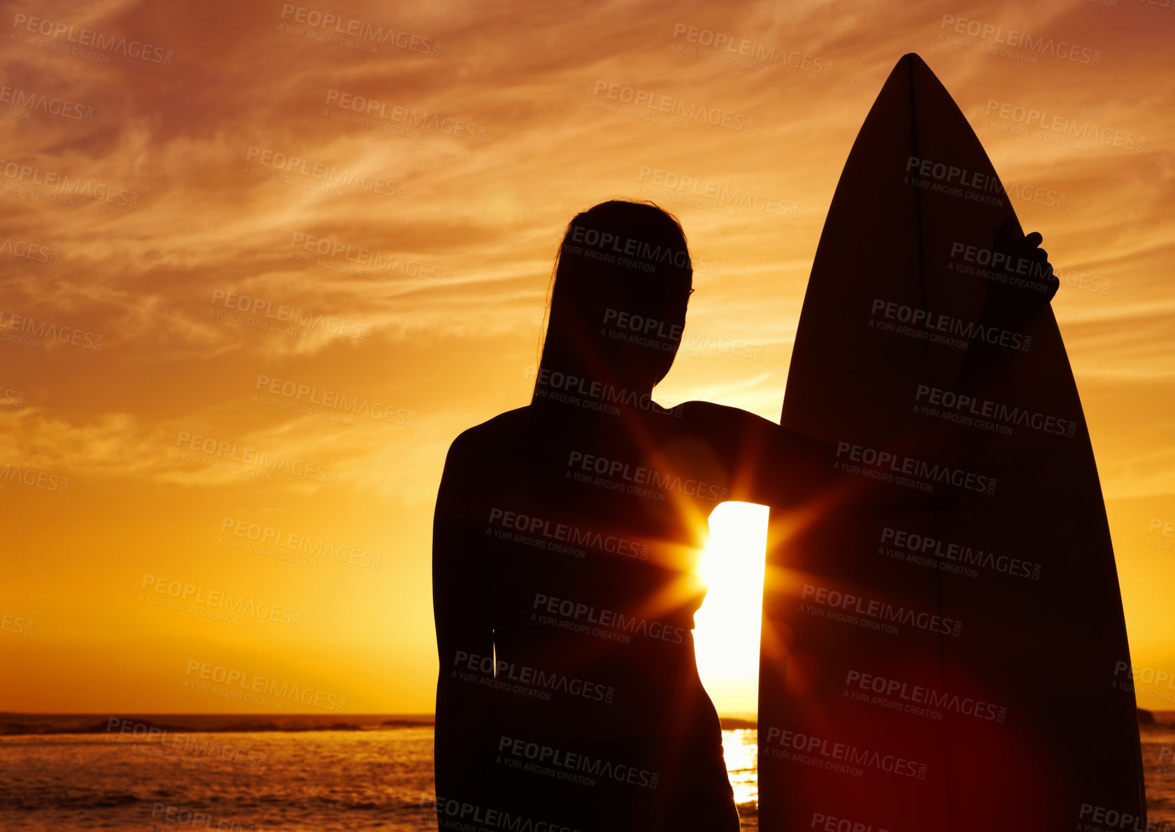 Buy stock photo Silhouette of a beautiful woman holding a surfboard at sunset
