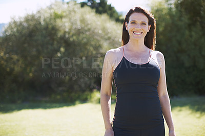 Buy stock photo An attractive woman in sports clothing smiling while standing in the outdoors