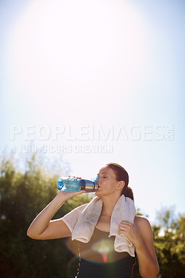 Buy stock photo An attractive woman drinking from her water bottle after a workout