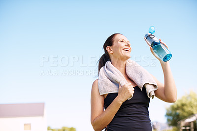 Buy stock photo An attractive woman standing with her water bottle after an outdoor workout