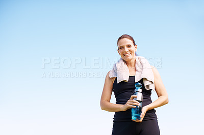 Buy stock photo Portrait of an attractive woman standing with her water bottle after an outdoor workout