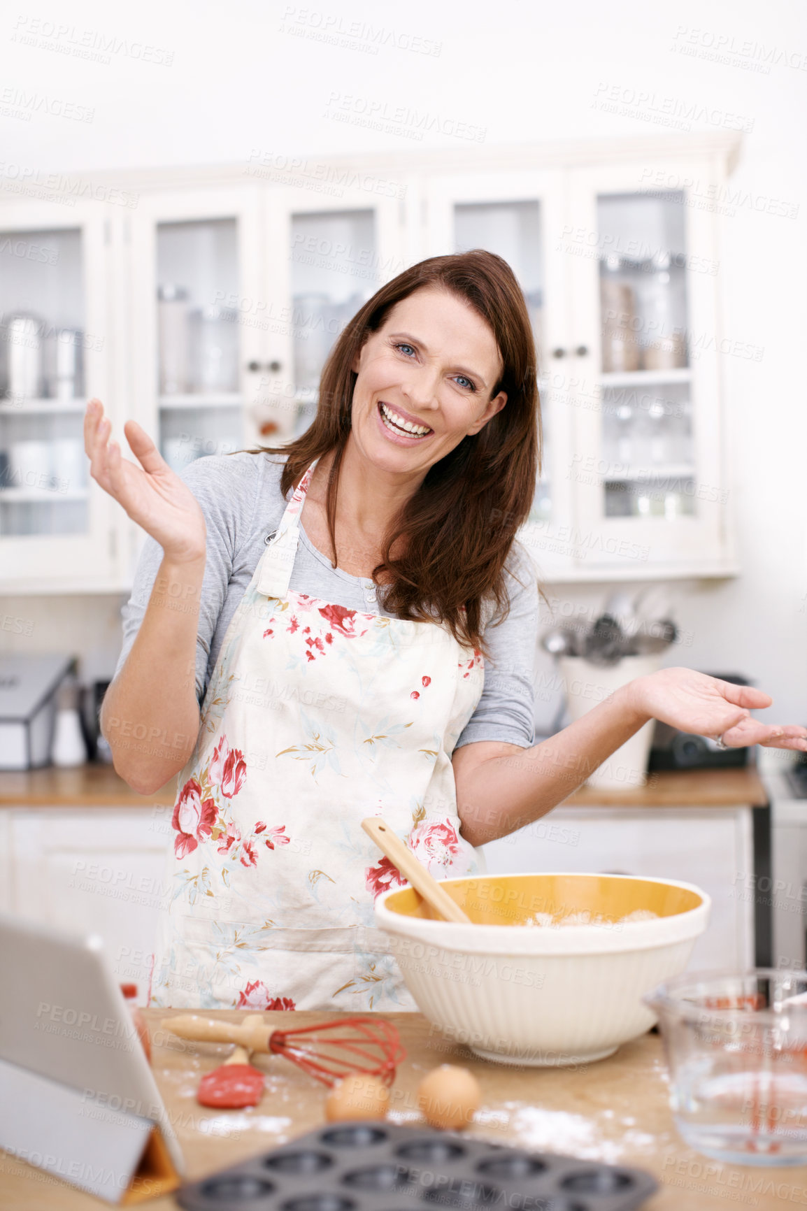 Buy stock photo Portrait of a mature woman standing with her arms raised while baking in the kitchen