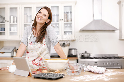 Buy stock photo An attractive woman looking pensive while baking in the kitchen
