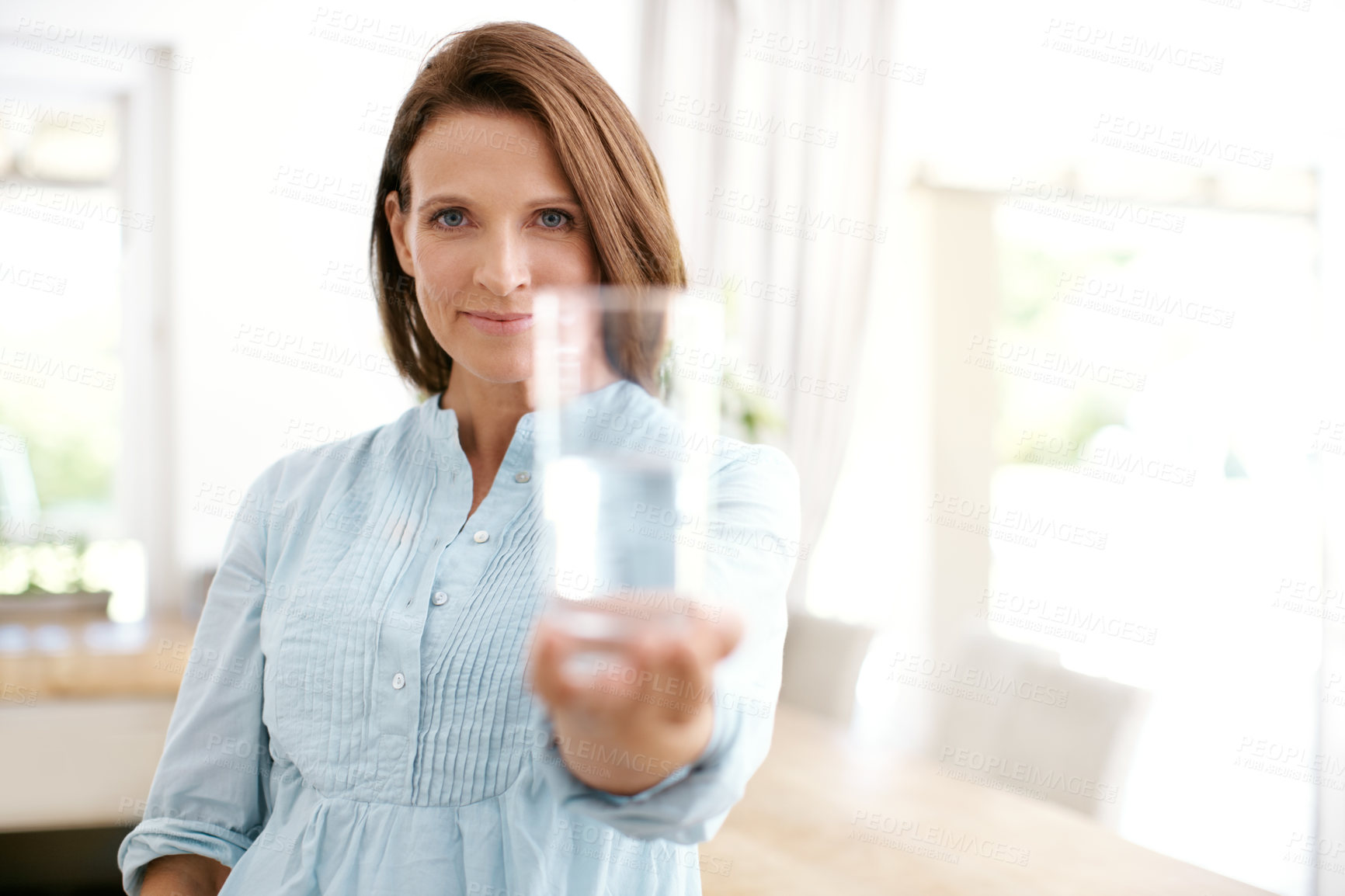 Buy stock photo Portrait of a mature woman showing you a glass of water