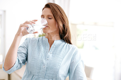 Buy stock photo A mature woman drinking a glass of water with the eyes closed