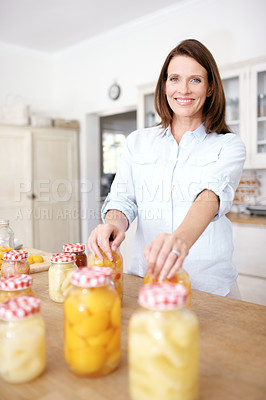 Buy stock photo Mature woman, portrait and happy, healthy preserved peaches and food storage in kitchen. Nutritionist, home economics for harvest and housekeeping, cooking vegetables and fruit compote or pickled