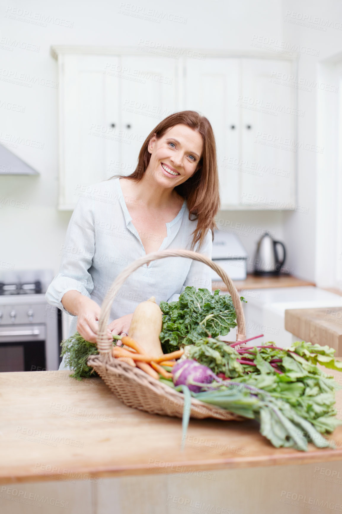 Buy stock photo Woman, vegetables and portrait in kitchen for organic, food and nutrition for happiness. Vegan, basket and health for cooking, diet and smile for wellness in home with vitamins and female person