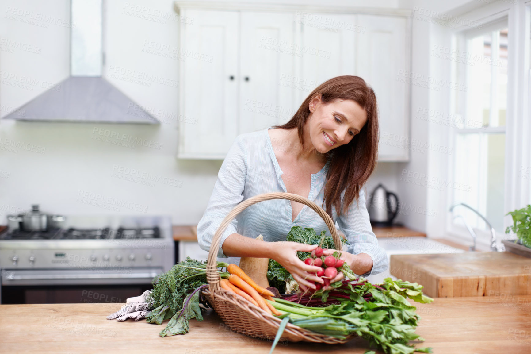 Buy stock photo Gardener, woman and fresh vegetables on kitchen table with gardening, growth and radishes in basket. Female person, harvest and nutrition for diet, healthy eating and sustainability in agriculture