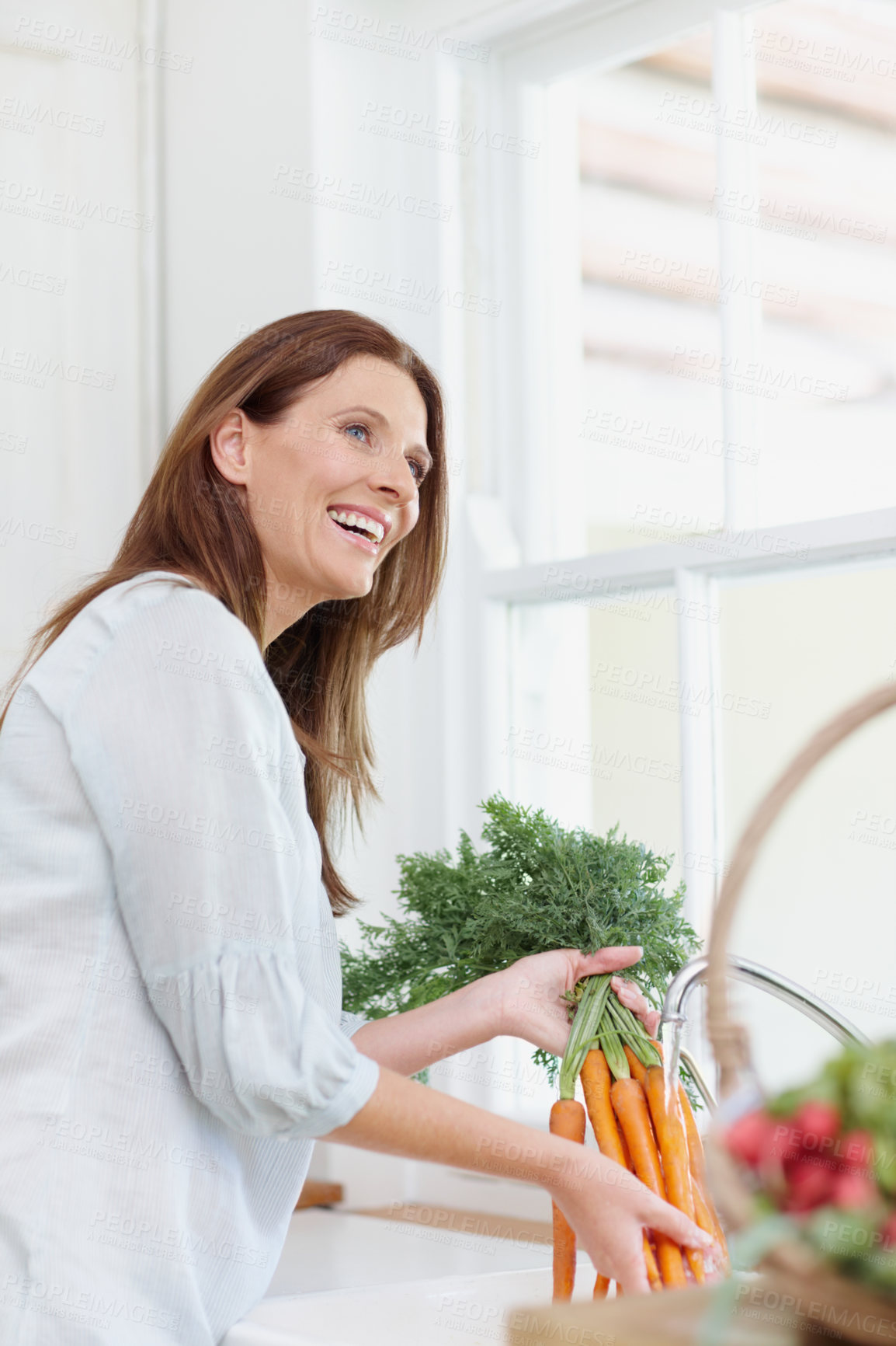 Buy stock photo Excited, woman and healthy food in kitchen with harvest, washing carrots in sink with vegetable basket. Female person, gardener and nutrition for diet, eco friendly and sustainability in agriculture