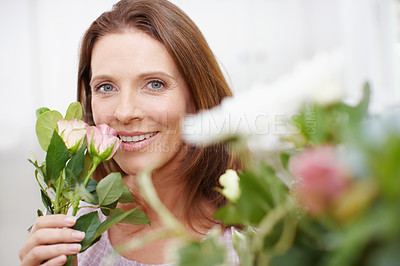 Buy stock photo Portrait of a beautiful woman arranging a bouquet of flowers