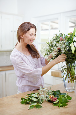 Buy stock photo A beautiful woman woman arranging a fresh bouquet of flowers
