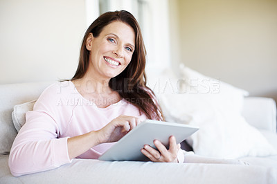 Buy stock photo Portrait of an attractive woman sitting on the sofa with her digital tablet