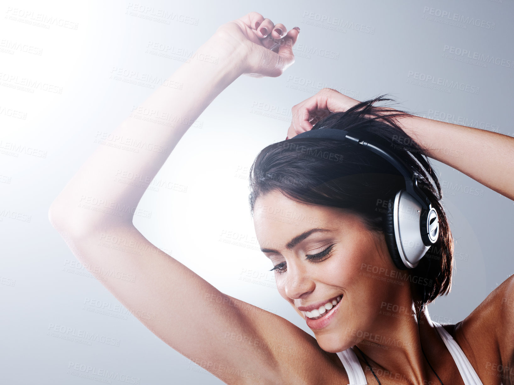 Buy stock photo Music, dance and happy woman with headphones in studio with freedom, party and celebration. Dancer, performance and person listening to audio track, song and radio for movement on gray background