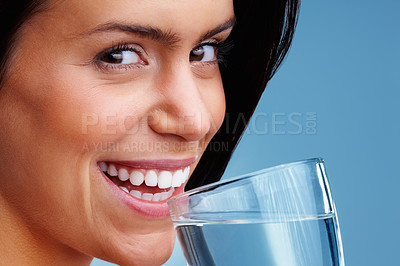 Buy stock photo Macro view of an attractive young woman drinking a glass of water