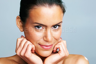 Buy stock photo Closeup of a young woman with hands on chin against colored background