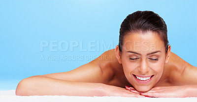 Buy stock photo Portrait of a relaxed young woman lying against blue background