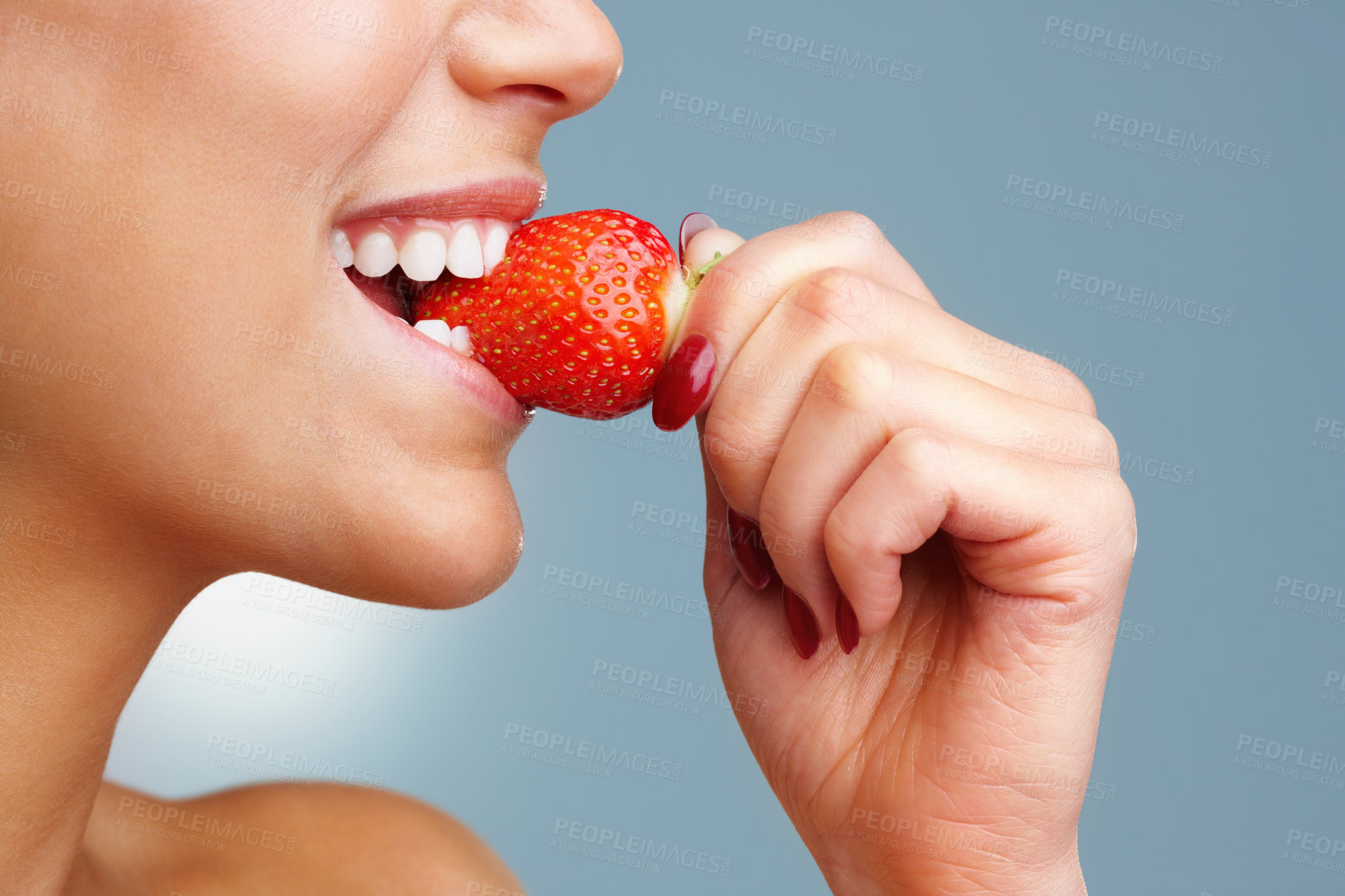 Buy stock photo Macro view of a pretty young woman eating fresh strawberry