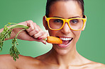 Young woman wearing glasses while eating fresh carrot
