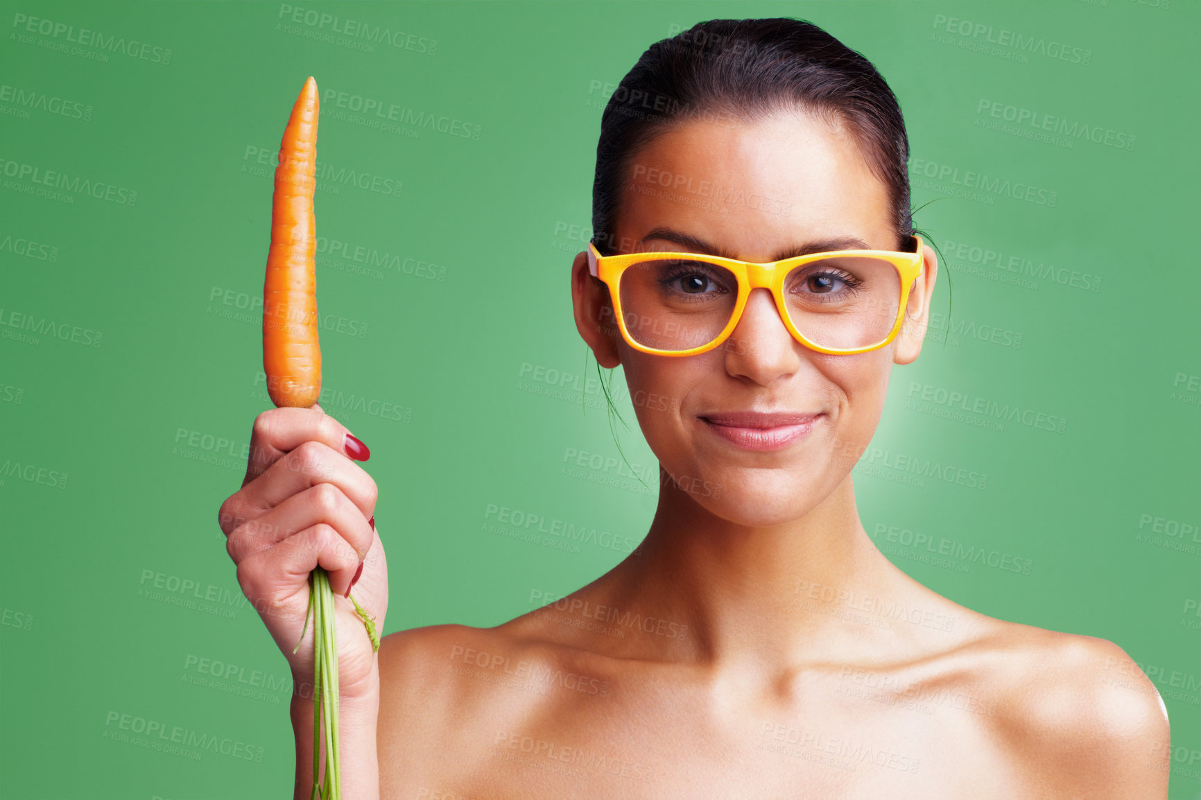 Buy stock photo Woman, portrait and glasses with carrots in studio on green background for vision, eyesight and healthy diet. Female person, smile and confident on eyewear or spectacles with nutrition or vegetables