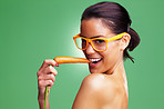 Seductive woman wearing glasses and eating fresh carrot